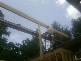 Carpenter setting a ridge beam over a new addition frame — Ice Dam Removal by Roofing Brothers in North Norwich
