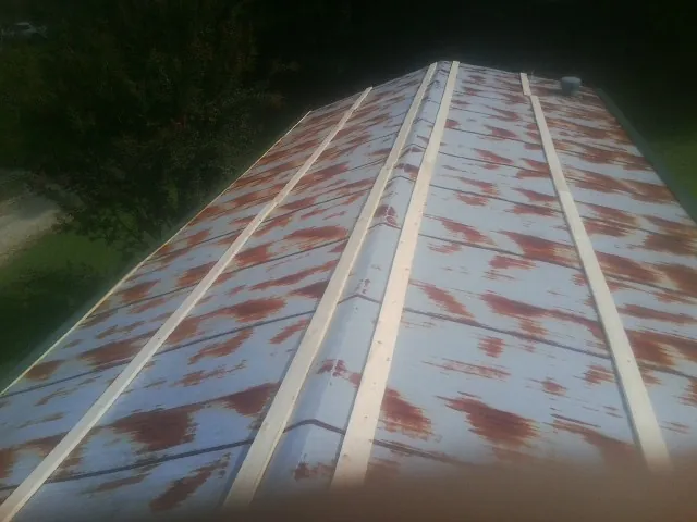 Rusted metal roof panels with new wood purlins before replacement — Storm Damage Roof Repair in North Norwich by Roofing Brothers
