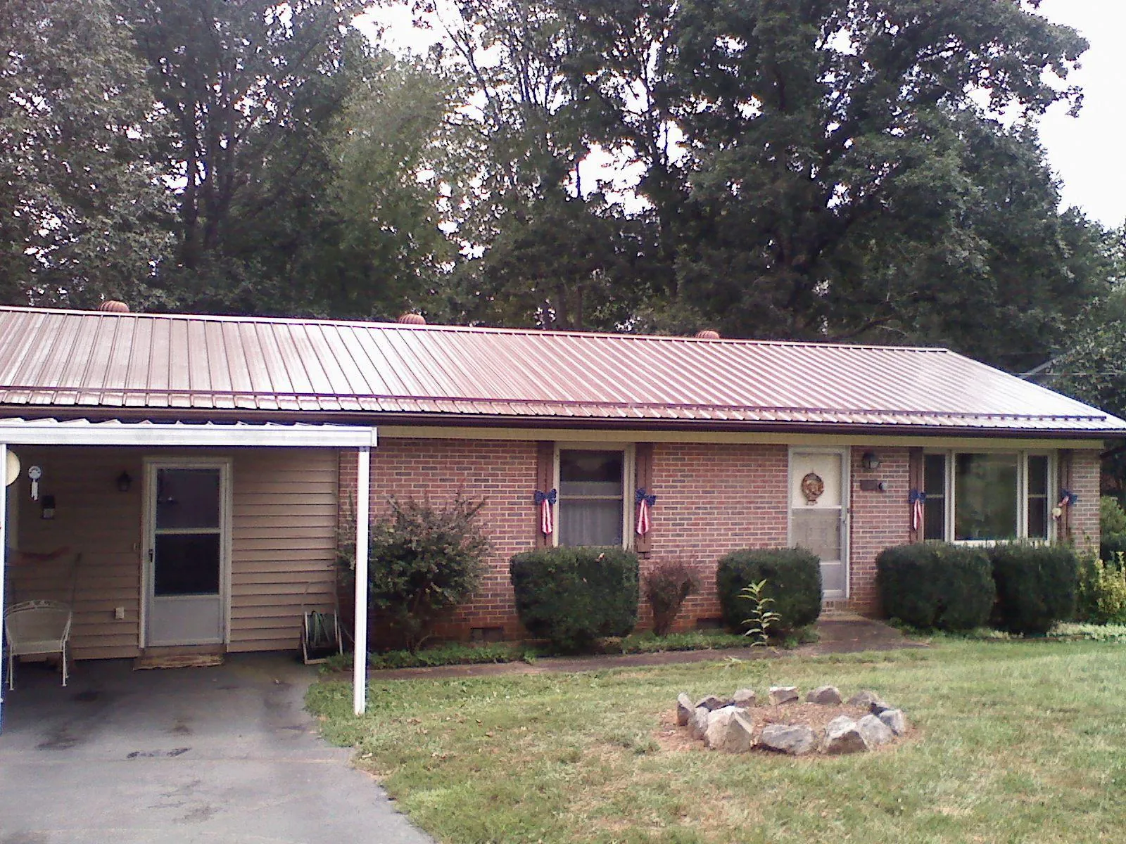 Bronze metal roof and carport on a brick ranch home — Roof Repair work by our crew in North Norwich